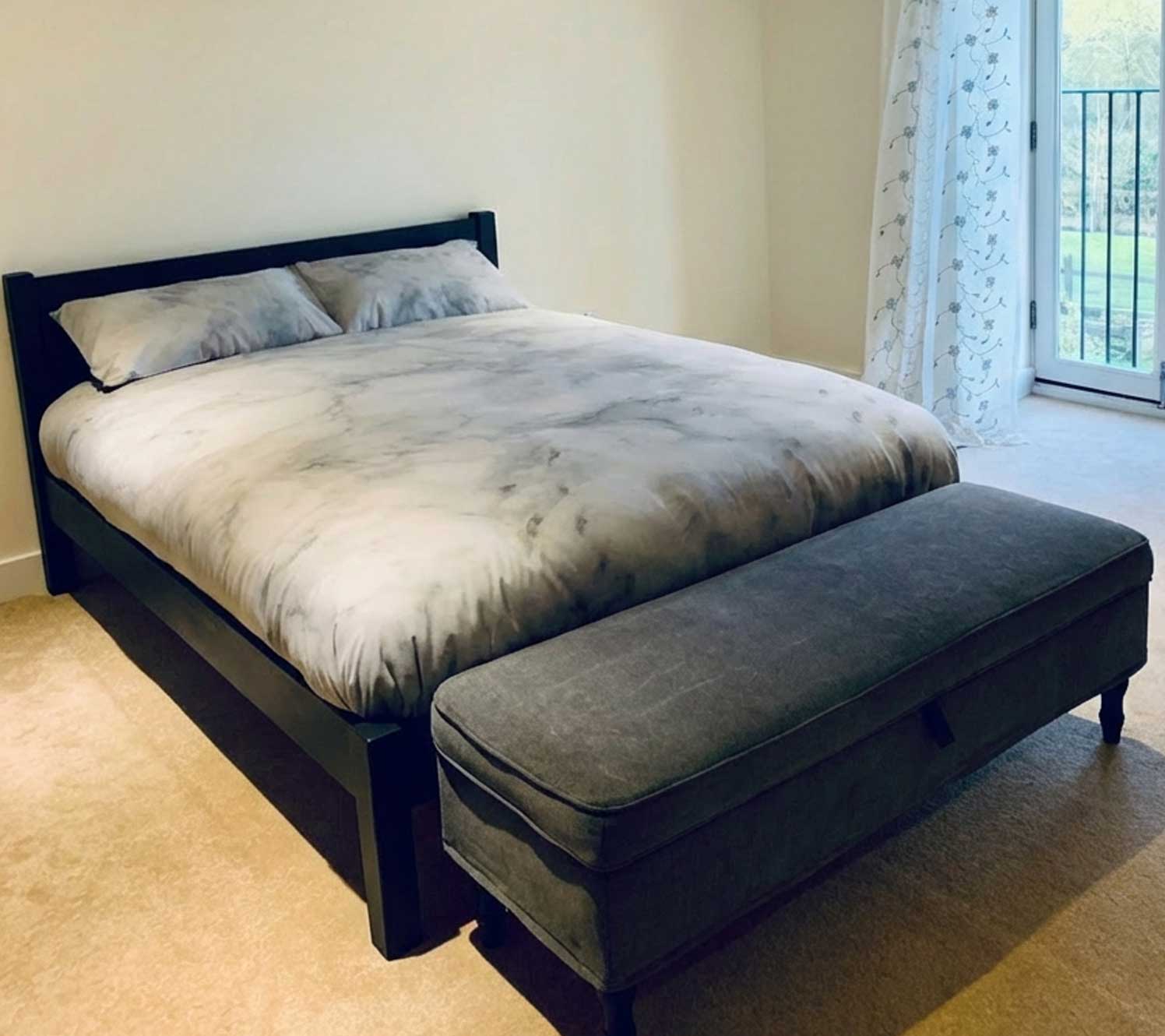 Black wooden frame in a cream and black bedroom